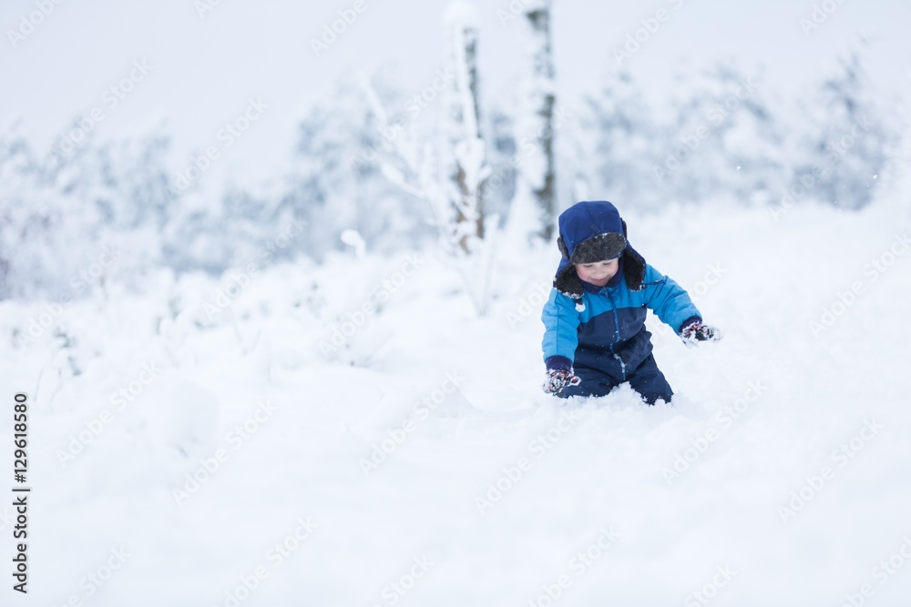 Happy caucasian child playing in snow