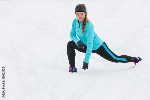 Winter workout. Girl wearing sportswear, stretching exercises.