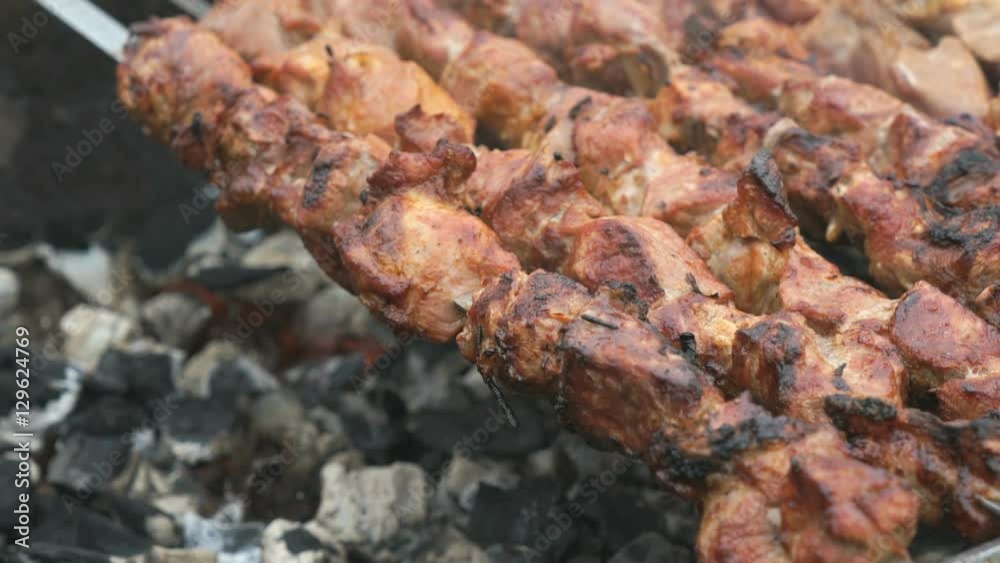 Cooking of pork shashlik on skewers on the grill outdoors. Close up Cooking of pork shashlik on skewers on the grill outdoors. Close up