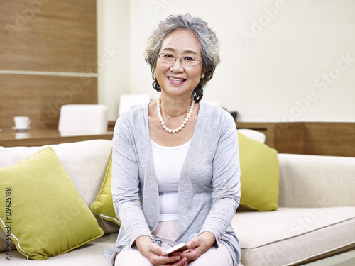 Fotografie portrait of senior asian woman sitting on couch at home
