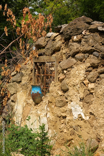 Abandoned house with blue enamel vase on the windowsill