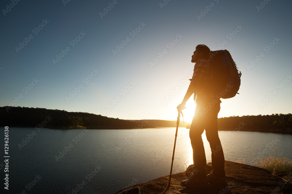 Silhouette of hiker man with backpack in beautiful sunset summer