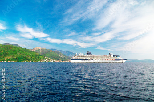 Cruise liner ship swimming at blue adriatic sea, mountains landscape