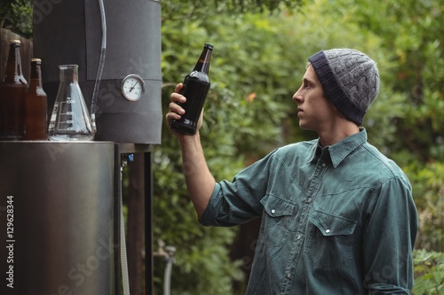 Man holding beer bottle while making beer
