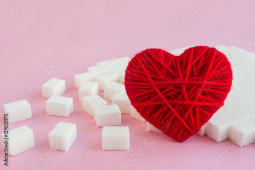 I love sugar cubes. Red woolen heart. Pink background