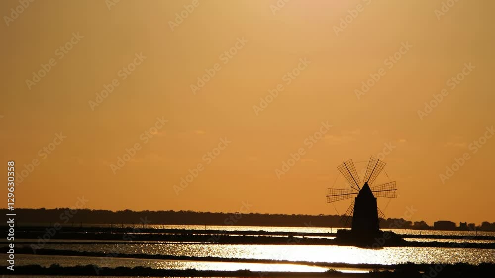 windmill at sunset: sky, sun, yellow, salt pans of Trapani, Sicily, Italy windmill at sunset: sky, sun, yellow, salt pans of Trapani, Sicily, Italy