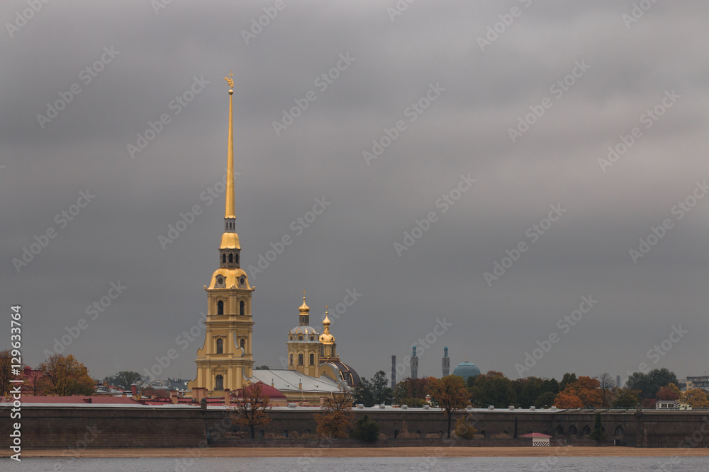 Glided cupola of Peter and Paul Cathedral agains gray moody sky