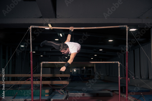 man gymnast hanging, horizontal bar