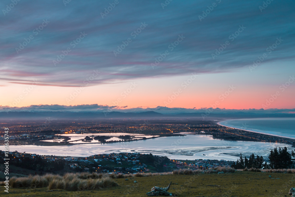 Sunset over city on ocean shore