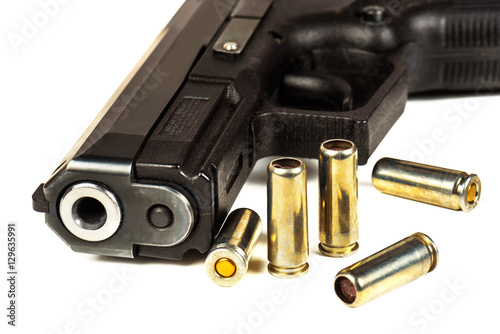 The black gun and cartridges to him on a white background close up.