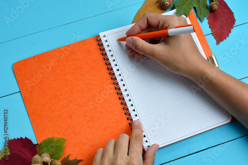 hand is writing on blank notebook