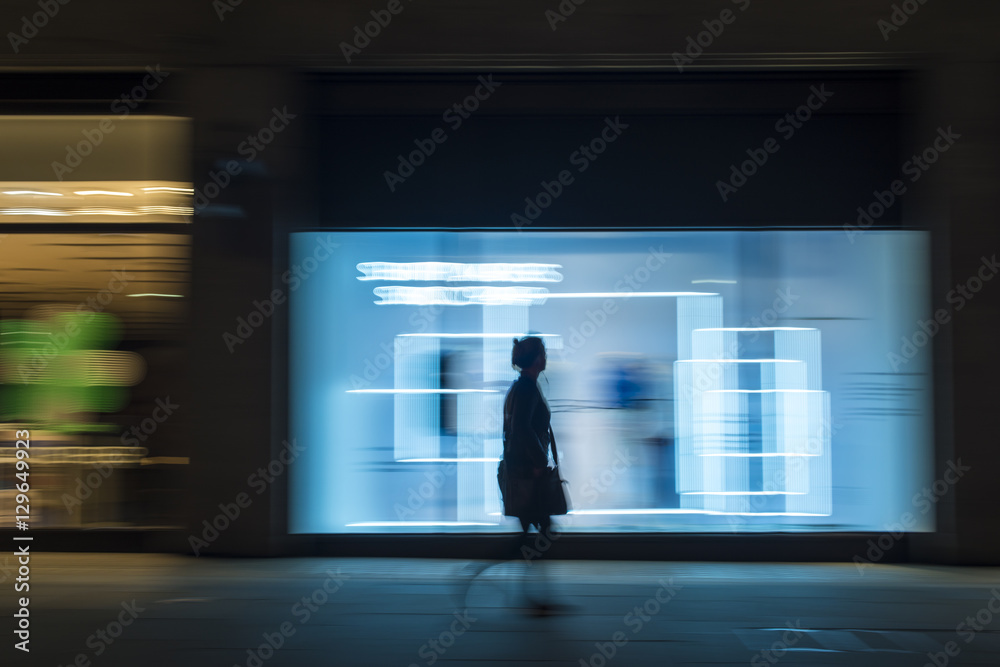 Pedestrian in a rush in the city walking at night on Oxford Street, London Pedestrian in a rush in the city walking at night on Oxford Street, London