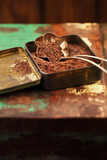 grated dark chocolate in vintage tin on wooden background