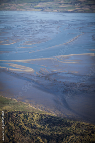 aerial view of the mudflat coastline at low tide with water winding in the mud and sand bank, Frisian island Ameland, The Netherlands