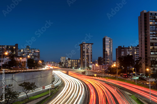 Light trails over H1 highway in downtown Honolulu, Hawaii during sunset golden hour