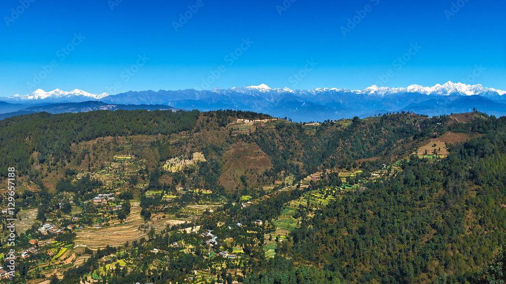 Panoramic view of Nepal with green valley and Himalayas snow peaks at the background