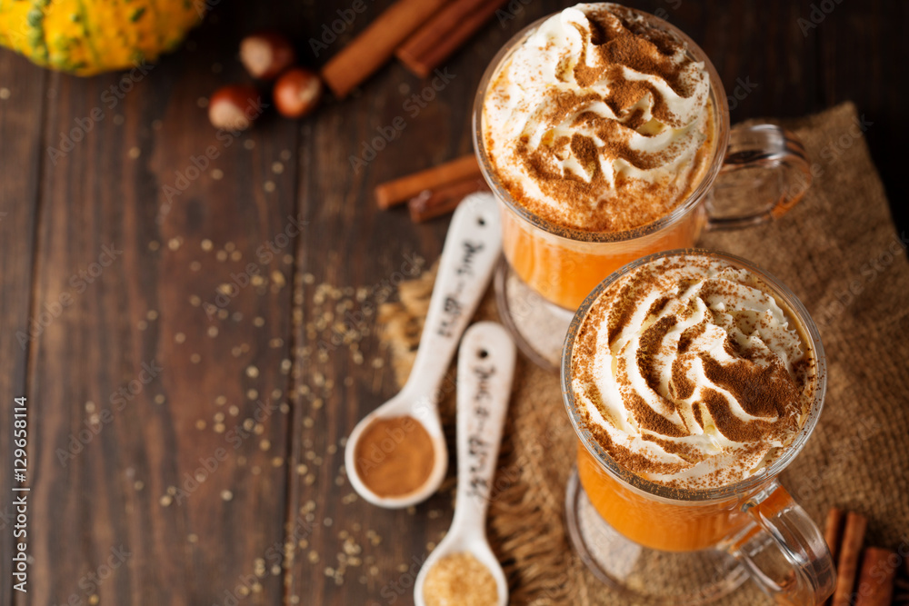 Pumpkin spice latte with whipped cream on top on rustic wooden background. Holiday autumn concept Pumpkin spice latte with whipped cream on top on rustic wooden background. Holiday autumn concept