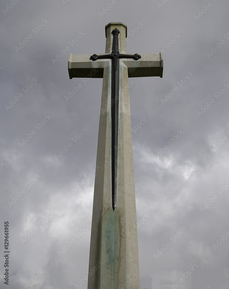 Stone cross with sword monument at a military cemetery Stone cross with sword monument at a military cemetery