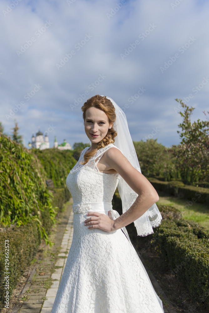 Redheaded girl in white long dress under the open sky Redheaded girl in white long dress under the open sky