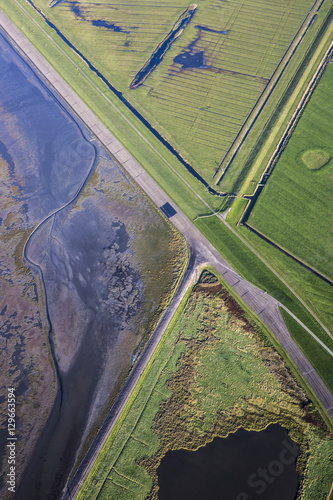 Aerial coastal view of the shore of Ameland Frisian Island with green fields, dike and sea, The Netherlands