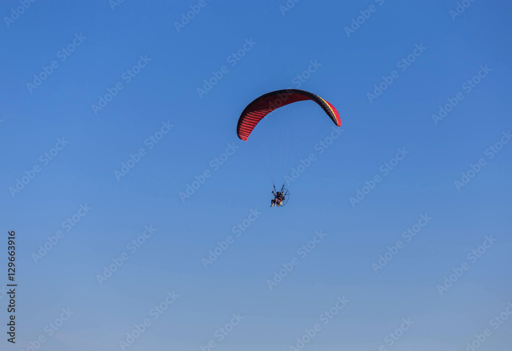 paraglider flying with paramotor on blue sky background paraglider flying with paramotor on blue sky background