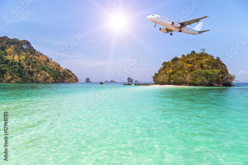 passenger airplane flying over above small island in tropical andaman sea. travel destinations concept