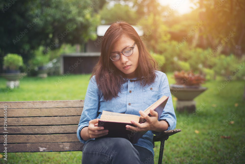 Hipster charming girl relaxing in the park while read book, Enjo Hipster charming girl relaxing in the park while read book, Enjo
