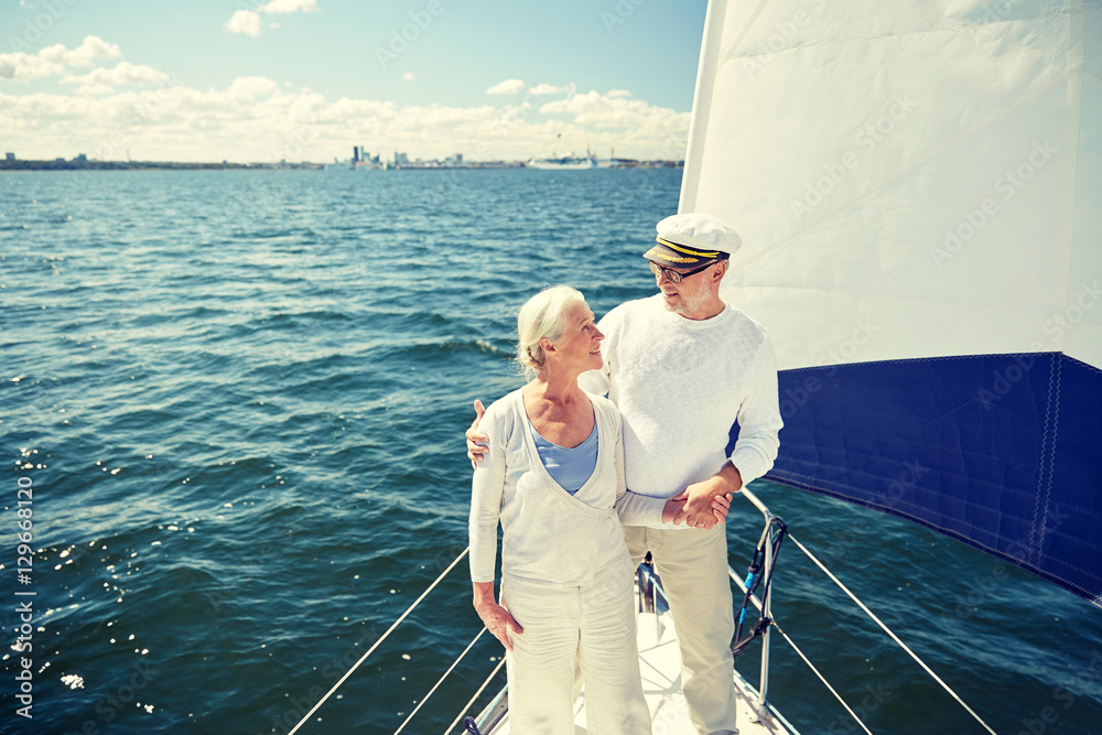 Fototapeta premium senior couple hugging on sail boat or yacht in sea