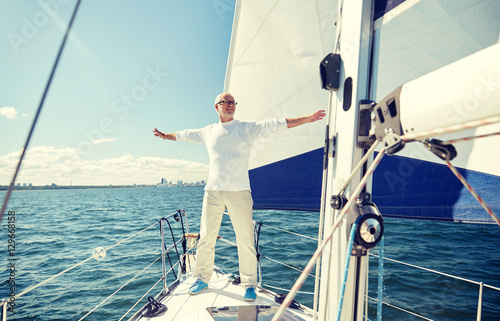 senior man on sail boat or yacht sailing in sea © Syda Productions