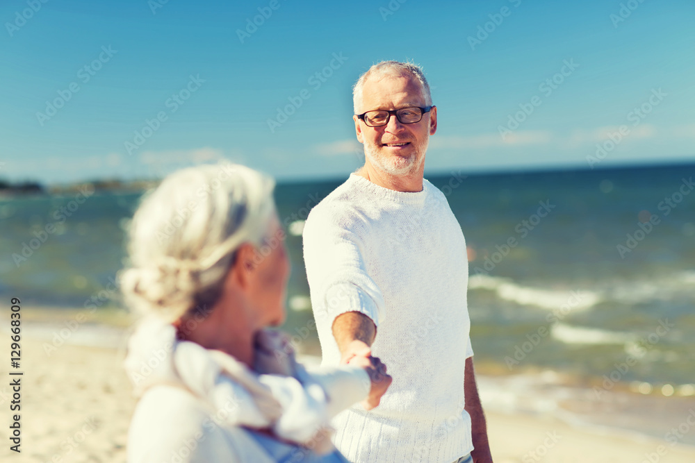happy senior couple holding hands on summer beach happy senior couple holding hands on summer beach