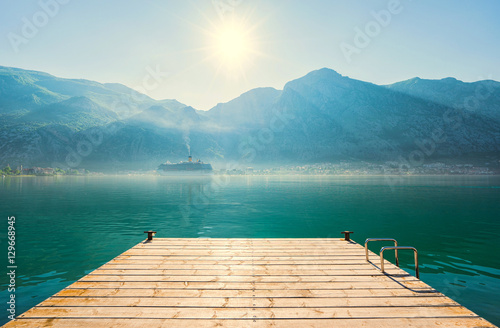 Early misty morning on the pier with sea, Kotor city and mountains on background. Kotor bay. Montenegro © upslim