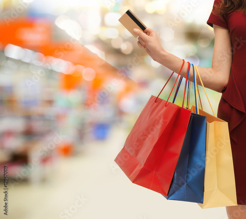 woman with shopping bags and credit card at store