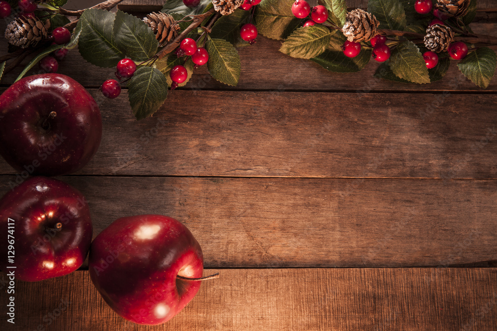 Wooden table with red apples a twig with red berries and cones. Wooden table with red apples a twig with red berries and cones.