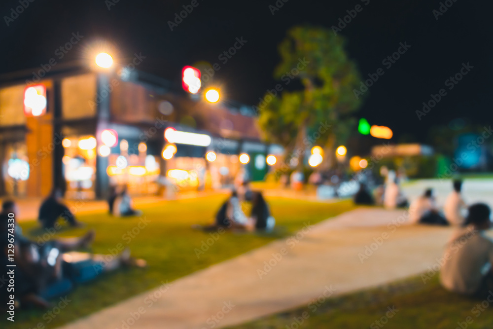 blurred people dinner at park with festive lights for background
