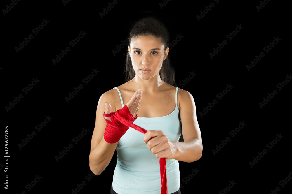 attractive hispanic fitness woman doing self hand wraps before boxing or fighting workout attractive hispanic fitness woman doing self hand wraps before boxing or fighting workout