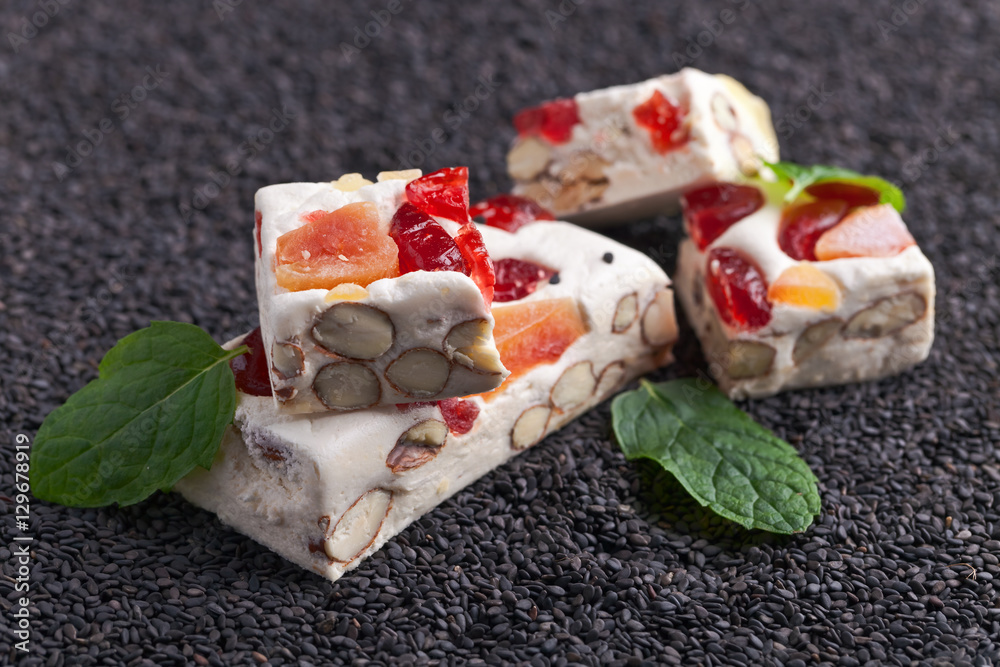 Soft nougat with tropical fruit and berries on black sesame Stock Photo ...