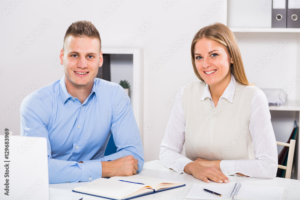 Obraz premium Portrait of businesswoman and businessman sitting in office and working together. 