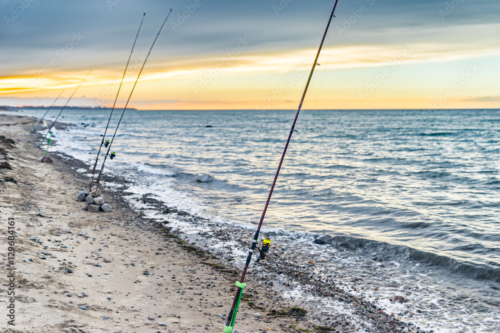 Angelruten am Strand der Ostsee bei Sonnenuntergang