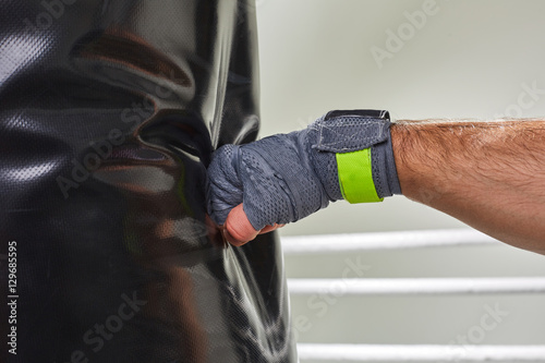 Young boxer training his skills hitting a punching bag.