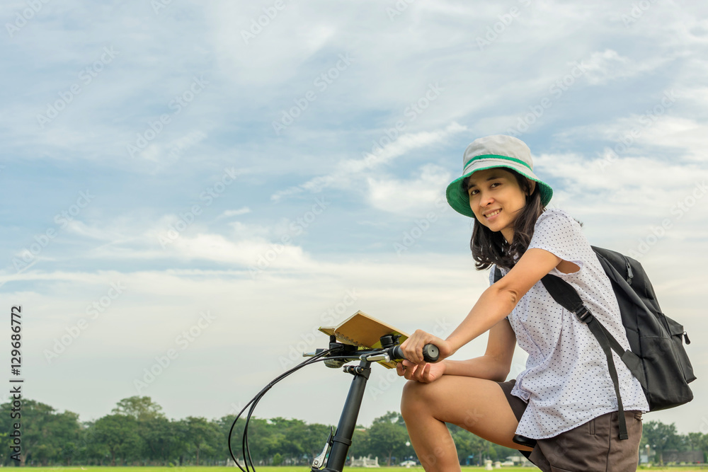 Obraz premium young student reading book and riding bicycle, freedom and learn