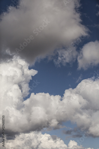 White fluffy storm clouds in blue sky