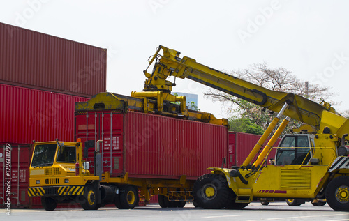 forklift handling the container box packed up transport trucks.