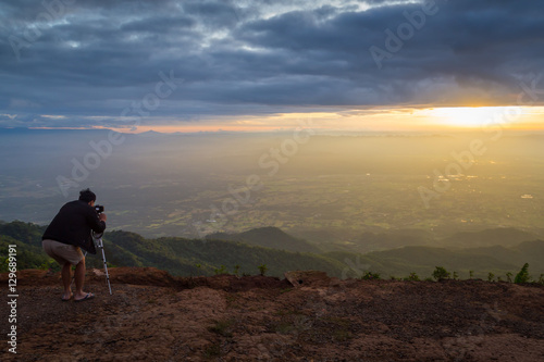 Tourists photograph the sunrise on a mountains.