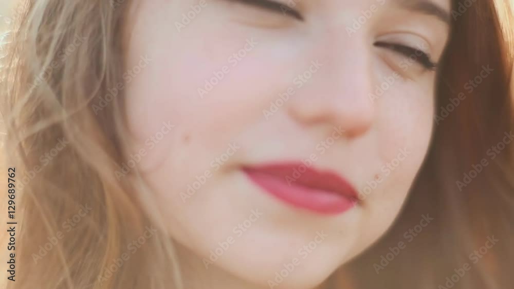 The sight of the redheaded girl with a smile on her face. Hair in the wind. Close-up. The sight of the redheaded girl with a smile on her face. Hair in the wind. Close-up.