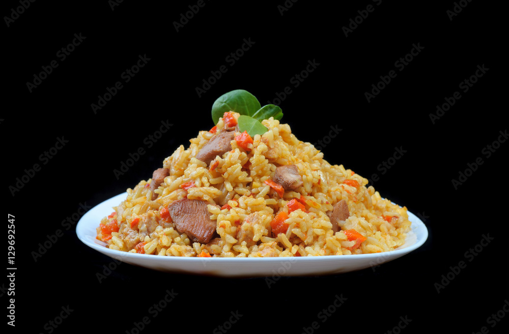 pilaf with meat and carrots on white plate and black background pilaf with meat and carrots on white plate and black background