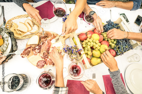 Top view of friend hands eating food and wine at barbecue garden party - People group enjoying fruit and sliced sausages at backyard meeting - Lunch and dinner concept outdoors - Bright vivid filter