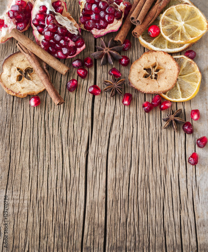 Dried citrus and garnet on a wooden background