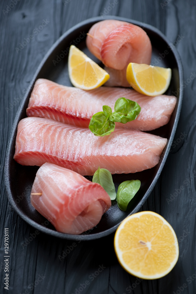 Close-up of marinated fillet of tilapia fish with lemon Close-up of marinated fillet of tilapia fish with lemon