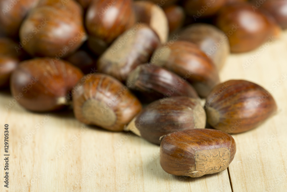 Chestnuts on pine wood background. Chestnuts on pine wood background.