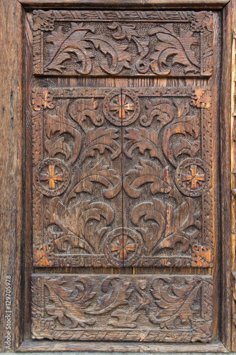 Old wooden door with carved patterns. Architecture